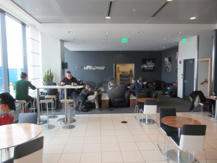 people sitting in a room with tables and chairs