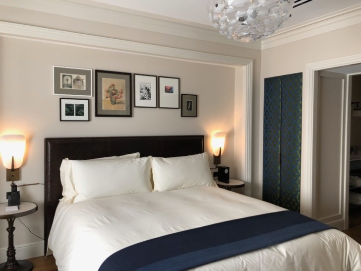 a bed with a lamp and pictures on the wall