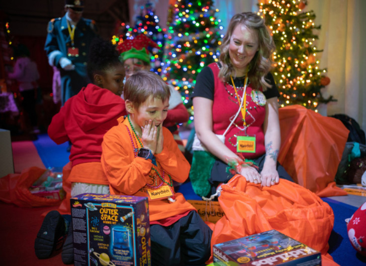 a group of people sitting on the floor with presents