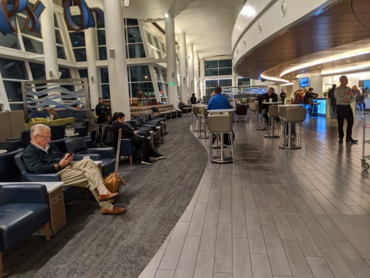 people sitting in chairs in a large room
