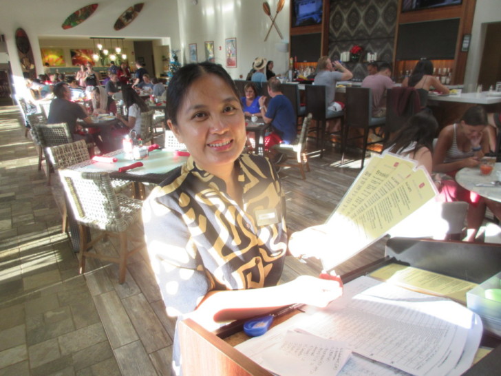a woman sitting at a table with a menu