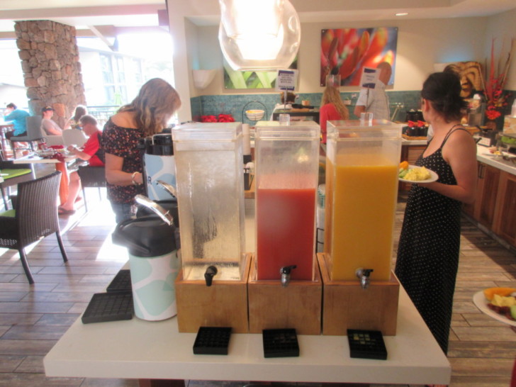 a group of people standing next to a table with drinks