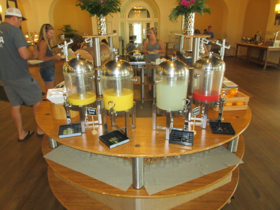 a table with several juice dispensers