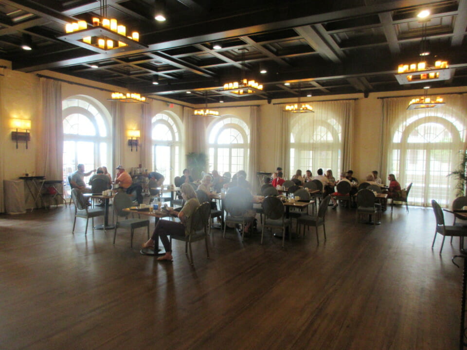 a group of people sitting at tables in a room with windows
