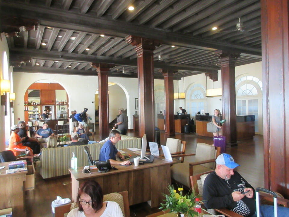 a group of people sitting at tables in a room with columns