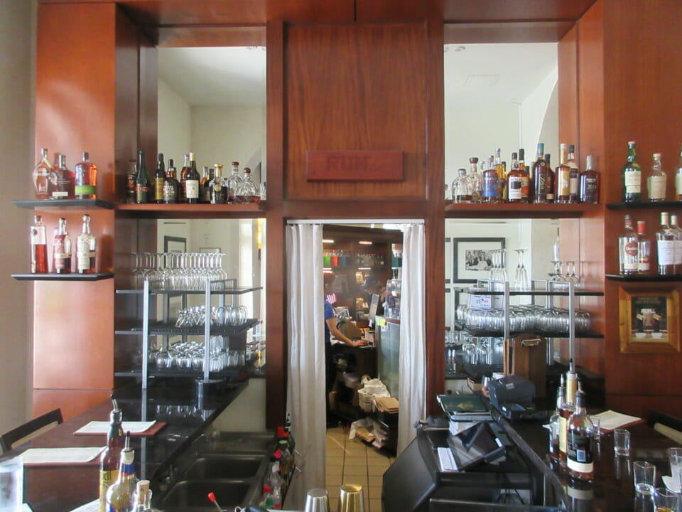 a room with shelves of liquor and glasses