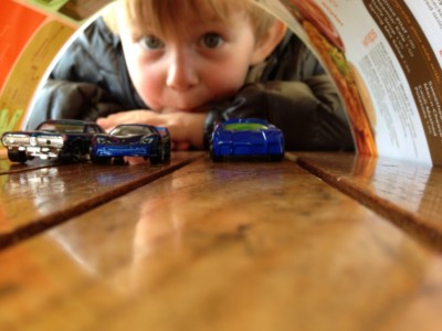 a child looking at a toy car