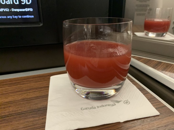 a glass of red liquid on a napkin