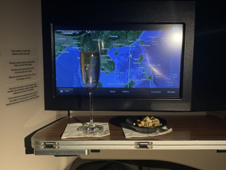 a glass of champagne on a tray with a television