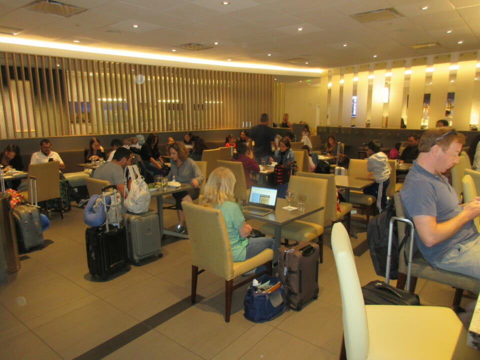 a group of people sitting at tables with luggage
