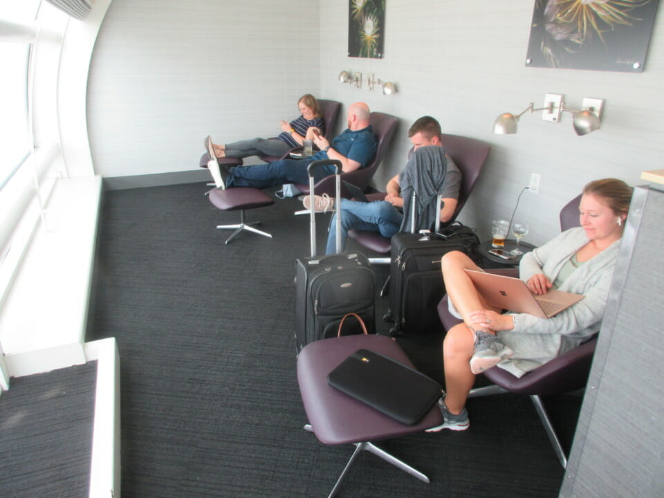 a group of people sitting in chairs with luggage