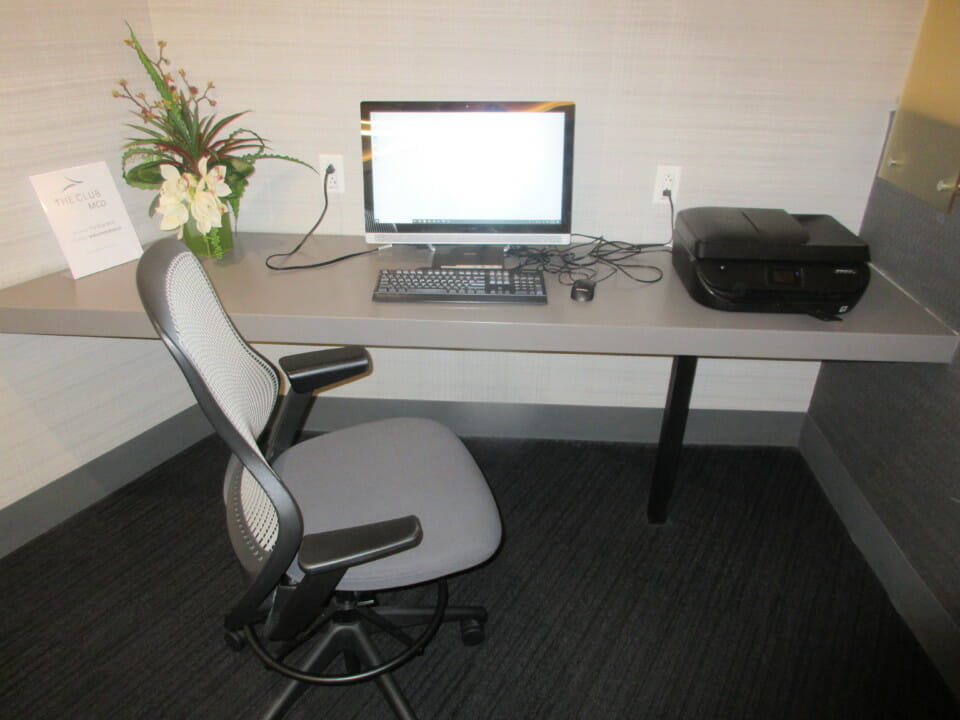 a desk with a computer and a printer