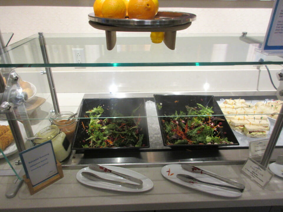 food on a shelf with plates and utensils