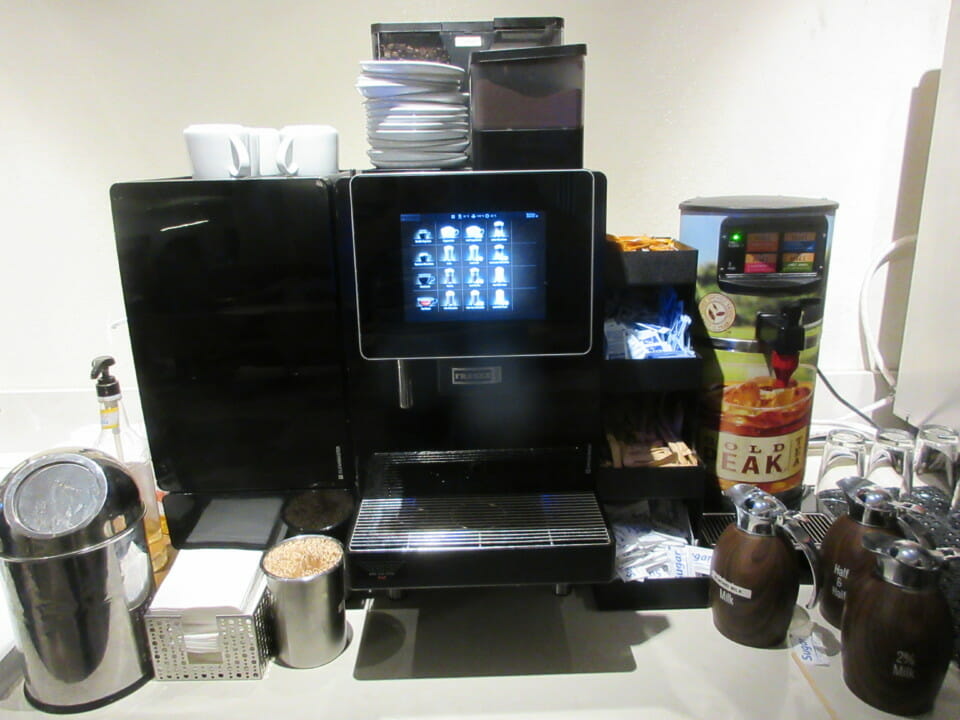 a coffee machine with a screen and a stack of plates