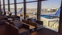 a room with chairs and tables and a plane in the background