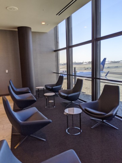 a group of chairs and tables in a room with windows