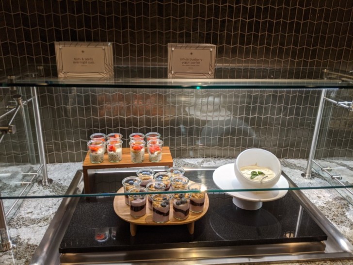 a glass display case with desserts and a bowl of yogurt