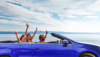 a group of people in a blue convertible car