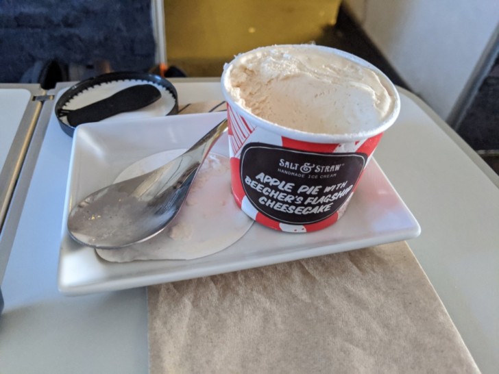 a cup of ice cream on a plate with a spoon