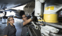 a man and woman working on a plane