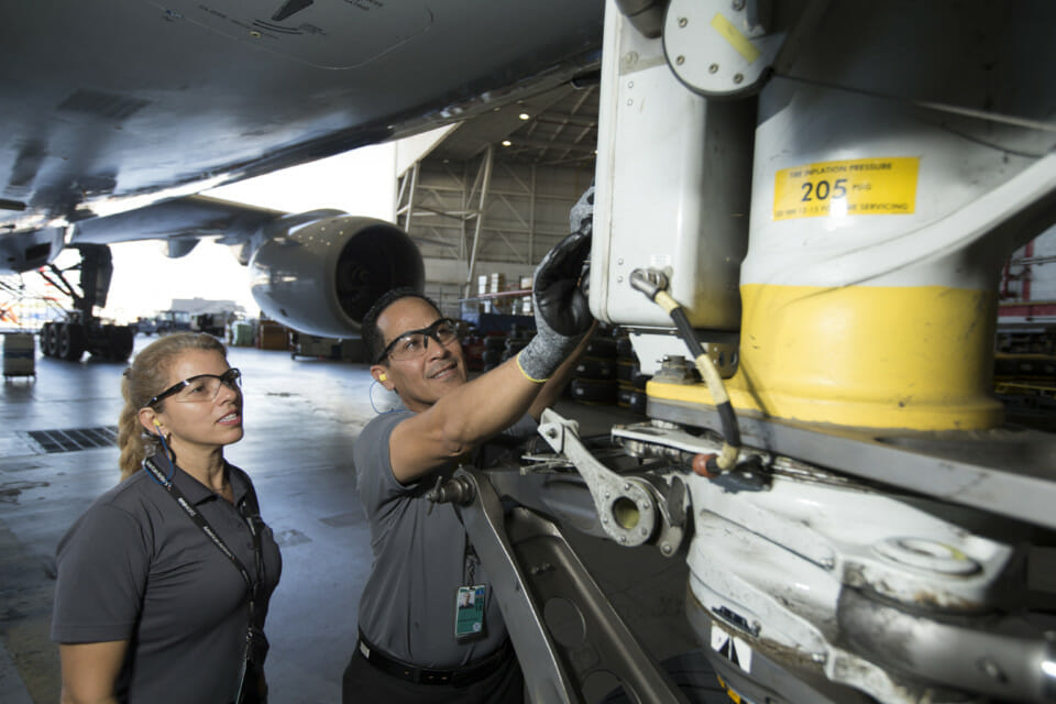 a man and woman working on a plane