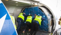 a group of people in vests loading a plane