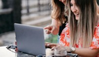 a group of women looking at a laptop