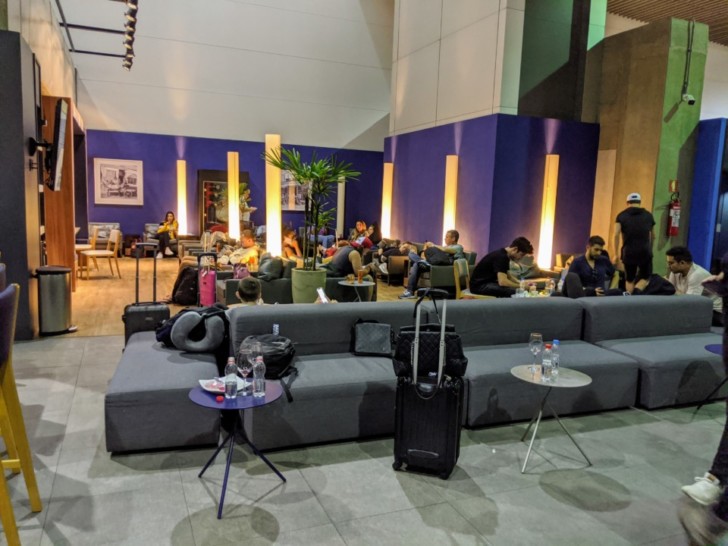 a group of people sitting in a room with a couch and chairs