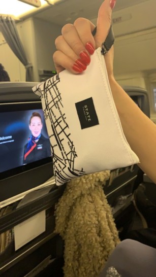 a hand holding a white bag with a black and white design