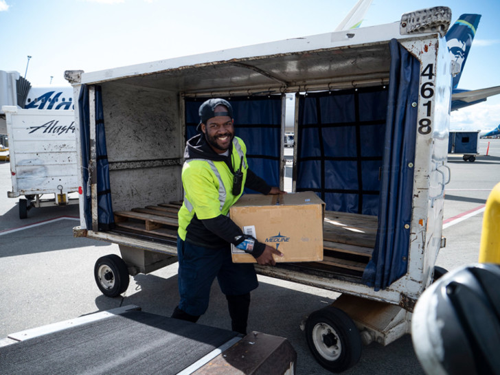 a man holding a box in the back of a truck