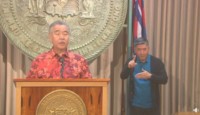 a man standing at a podium with a man pointing at him