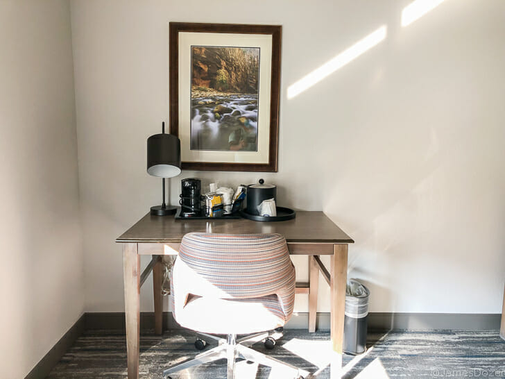 a desk with a chair and a picture on the wall