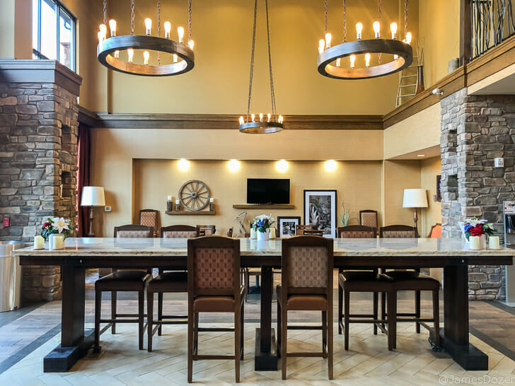 a large table with chairs in a room with a brick wall and a television