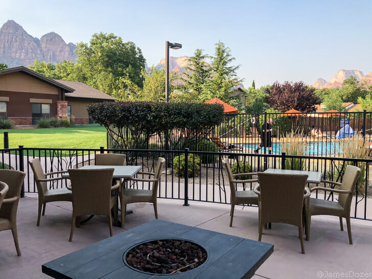 a patio with chairs and a fire pit
