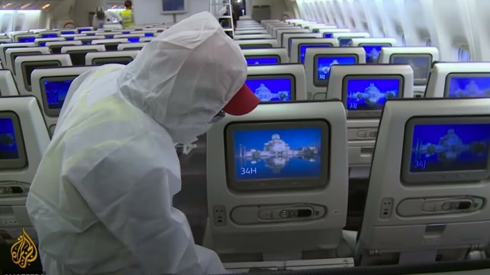 a person in a white suit looking at monitors