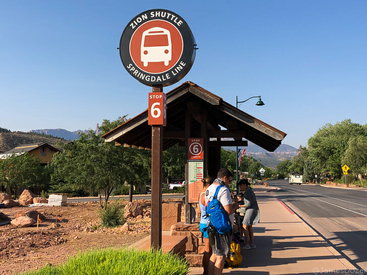 a group of people standing at a bus stop