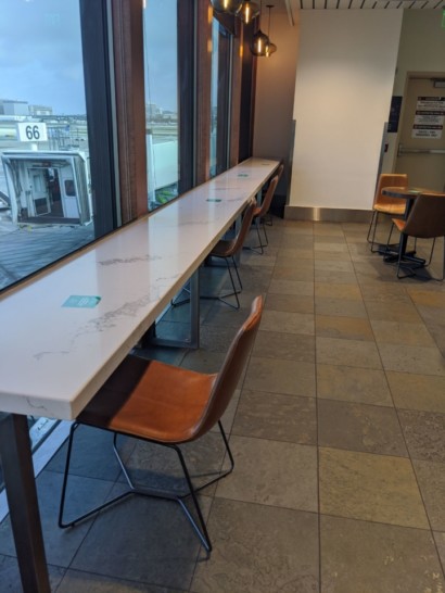 a long table with chairs in a room with a window