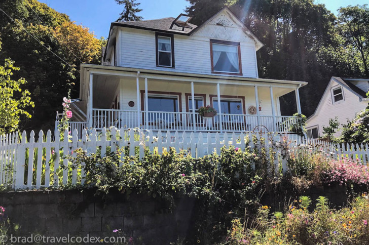a house with a white fence and plants