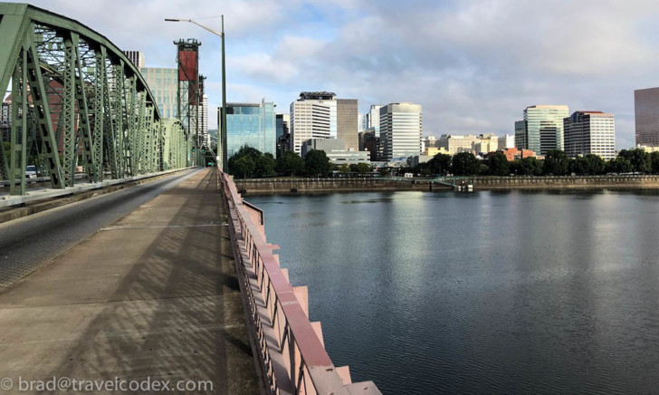 a bridge over a body of water with a city in the background