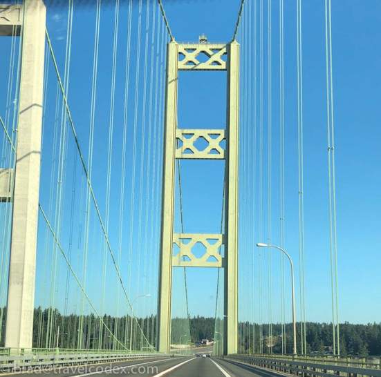 a bridge with a road and trees in the background
