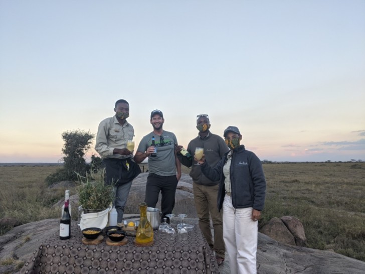 a group of people standing outside with drinks and bottles