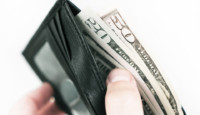 a hand holding a wallet full of money