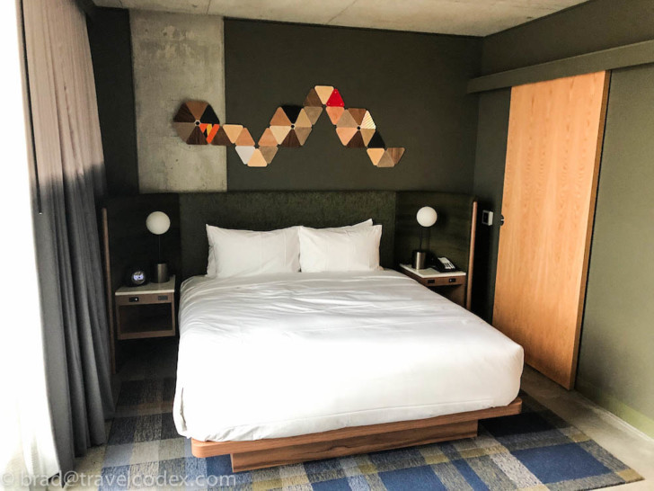a bed with white sheets and lamps
