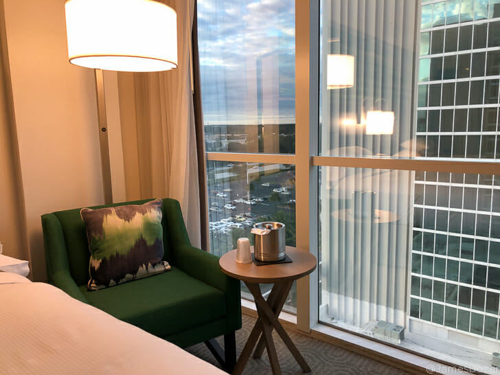 a room with a green chair and a table with a lamp