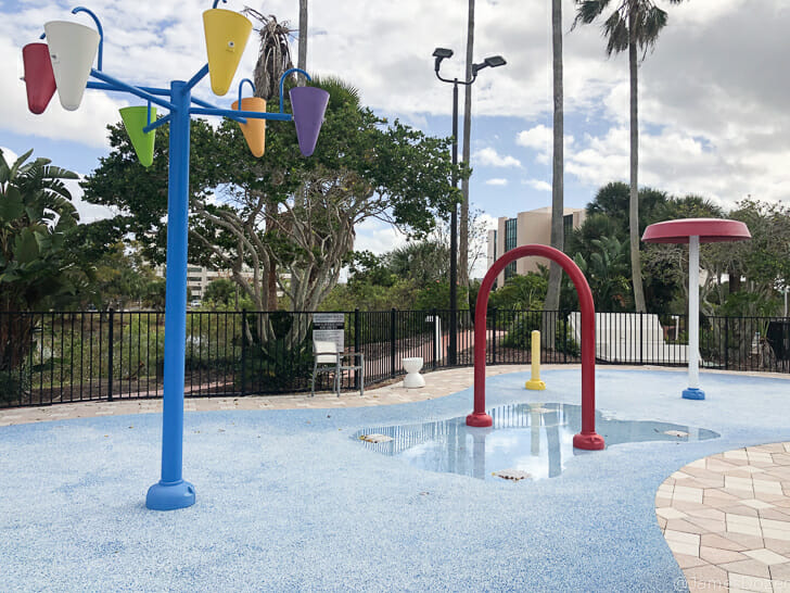 a colorful playground with water and trees