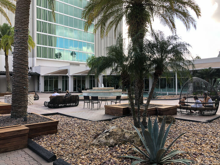 a courtyard with palm trees and a building