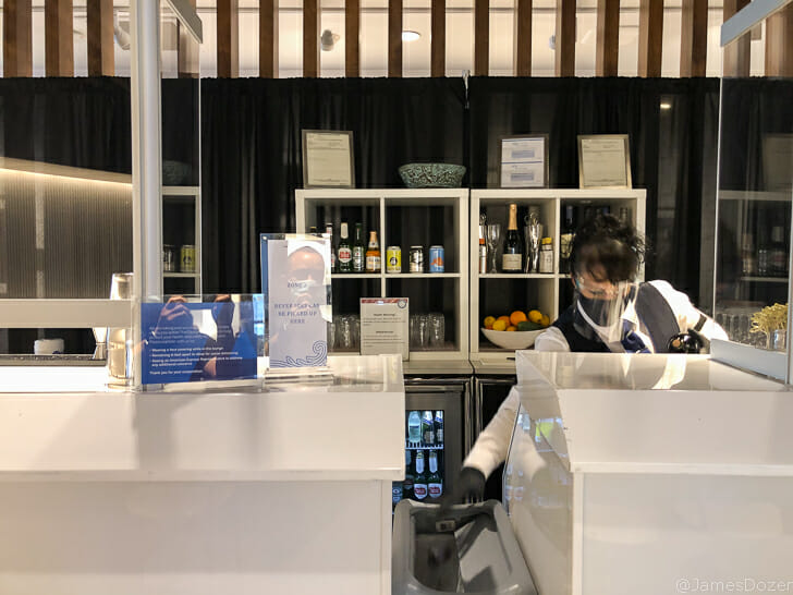 a woman wearing a face mask and standing behind a counter