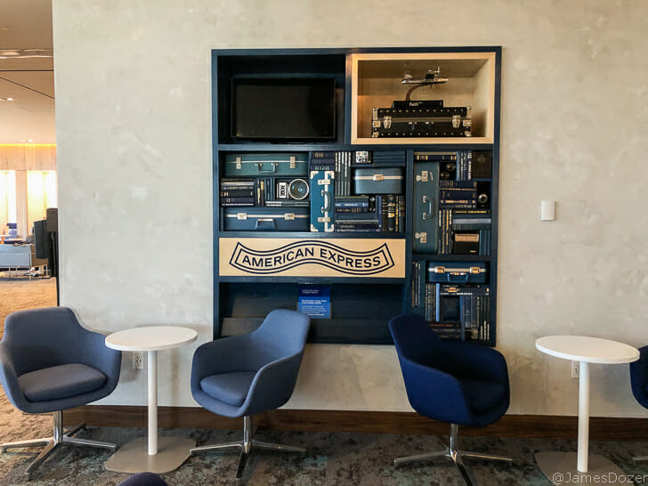 a room with a shelf with blue chairs and a television