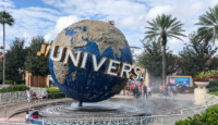 a large globe fountain with people around it