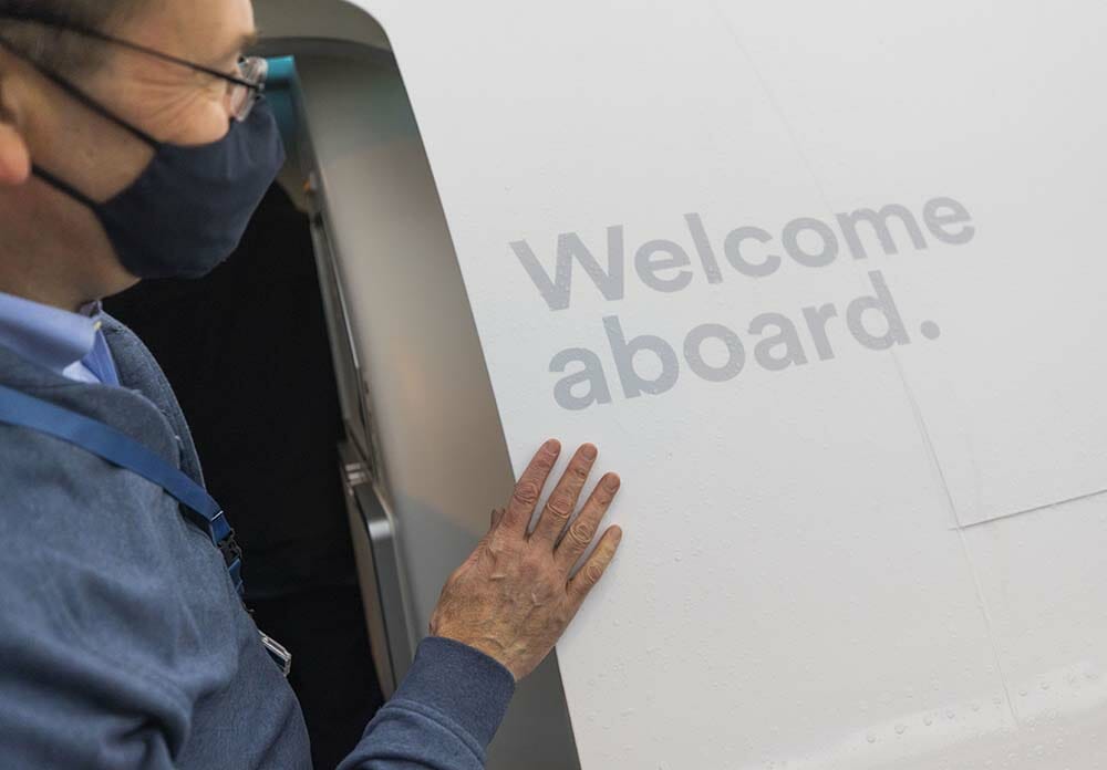 a person wearing a face mask touching a sign